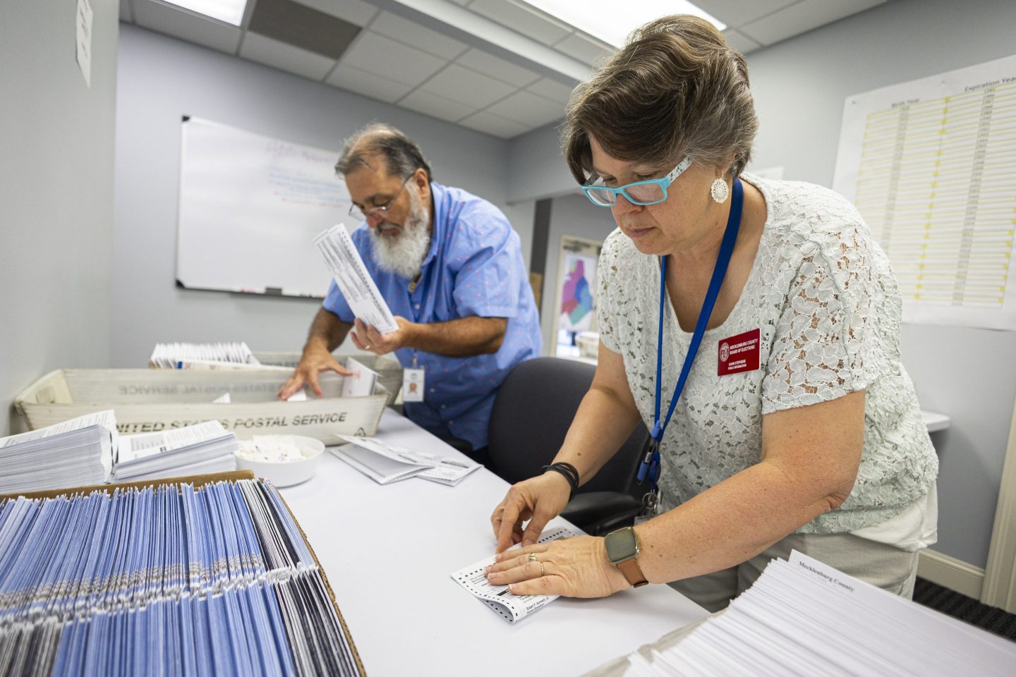 Dawn Stephens, right, and Duane Taylor prepare ballots to be mailed at the Mecklenburg County Board of Elections in Charlotte, N.C., Sept. 5, 2024.
