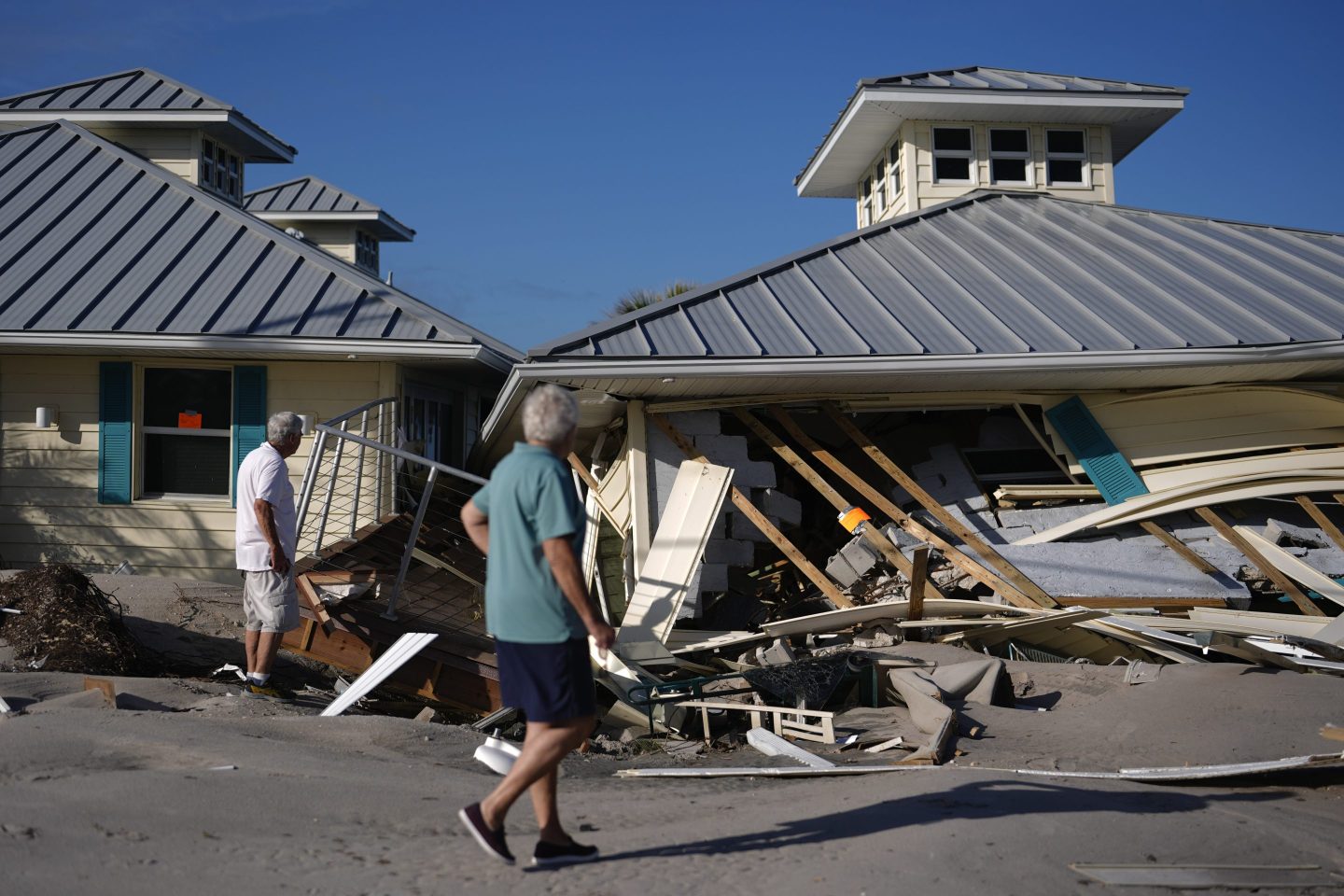 Property owners who preferred not to be named assess damage to their home and business, which bears orange notices calling for demolition, after the passage of Hurricane Milton, on Manasota Key in Englewood, Fla., on Oct. 13, 2024.