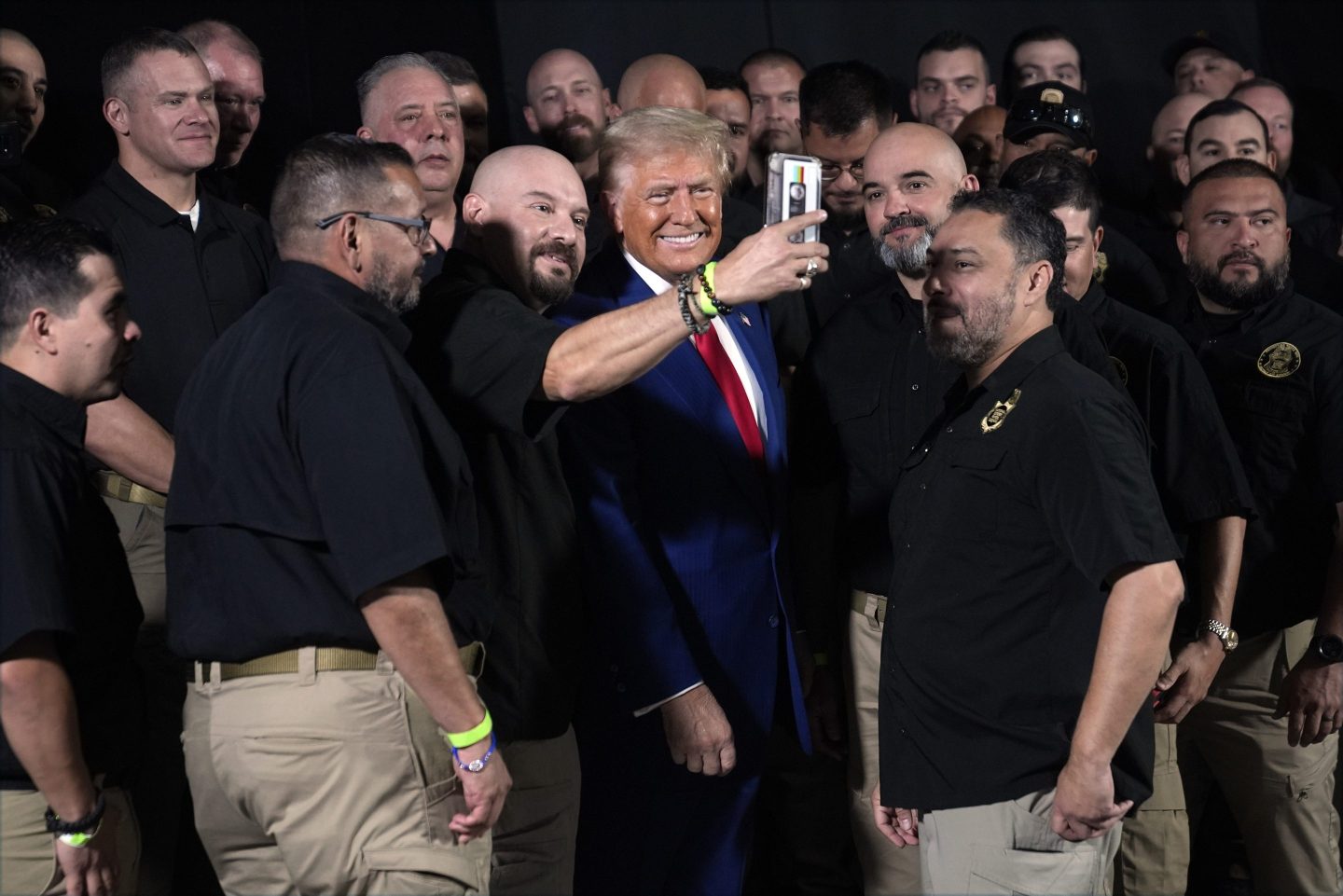 Republican presidential nominee former President Donald Trump talks with members of the U.S. Border Patrol before speaking at a campaign rally, on Oct. 13, 2024, in Prescott Valley, Ariz.