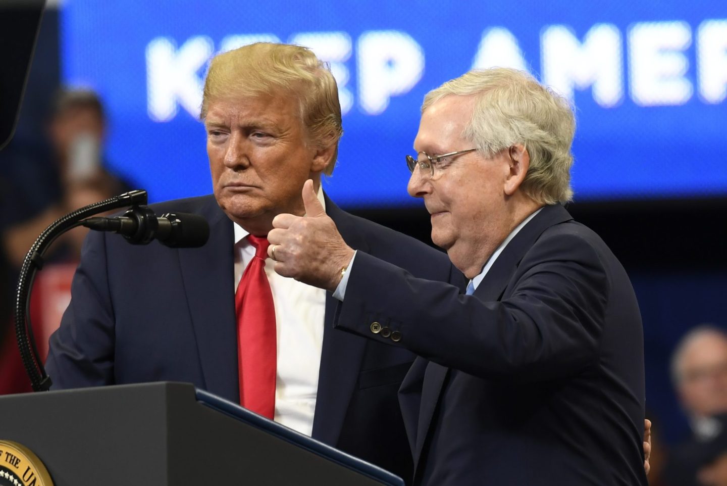 Mitch McConnell gives a thumbs up while standing next to Donald Trump