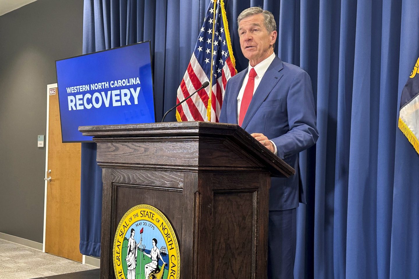 North Carolina Gov. Roy Cooper unveils a report about damages caused by Hurricane Helene and his $3.9 billion request to the General Assembly for recovery initiatives during a press conference at the Albemarle Building in Raleigh, N.C., on Oct. 23, 2024.