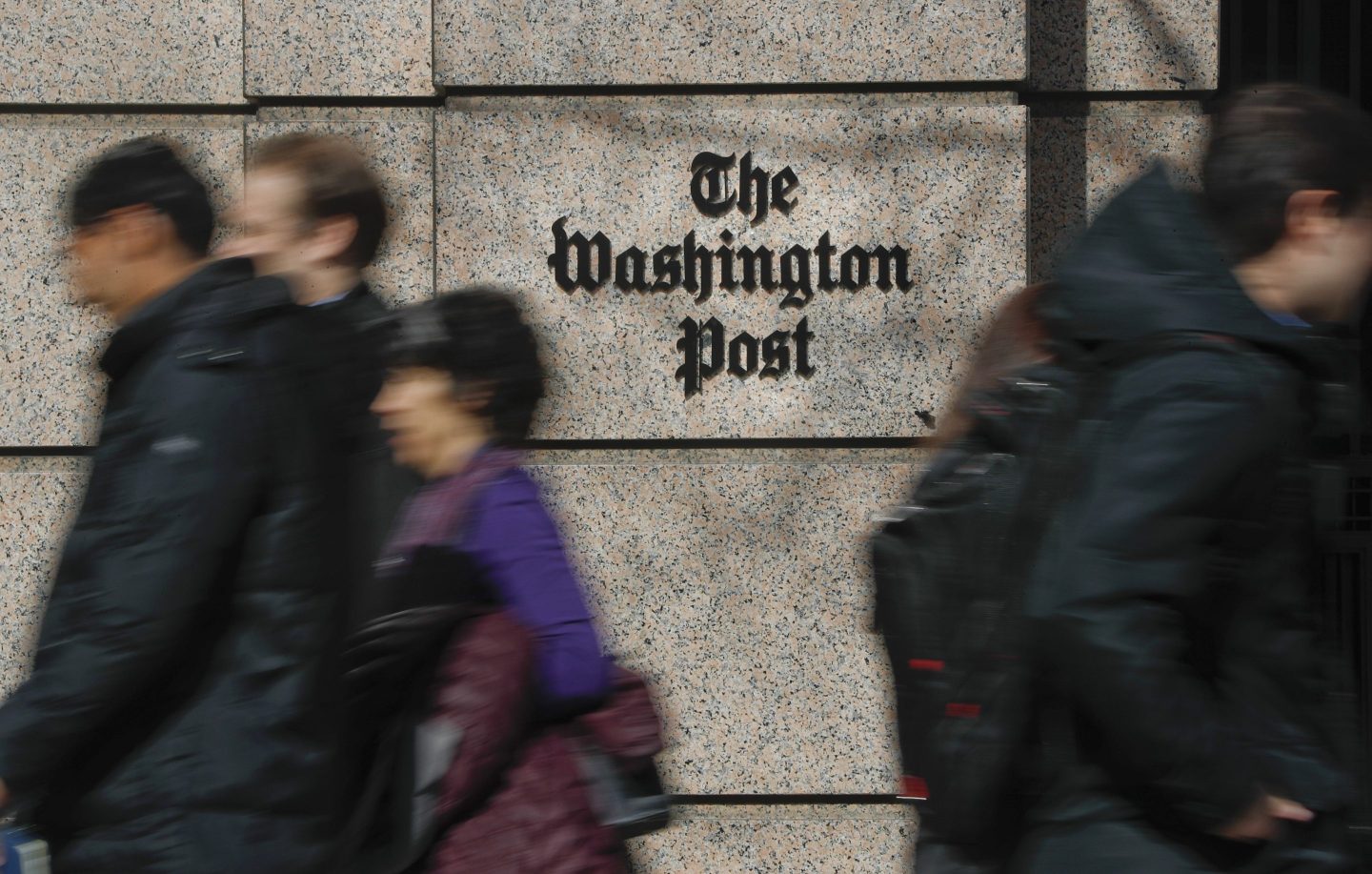 People walk by the One Franklin Square Building, home of The Washington Post newspaper, in downtown Washington, Feb. 21, 2019.