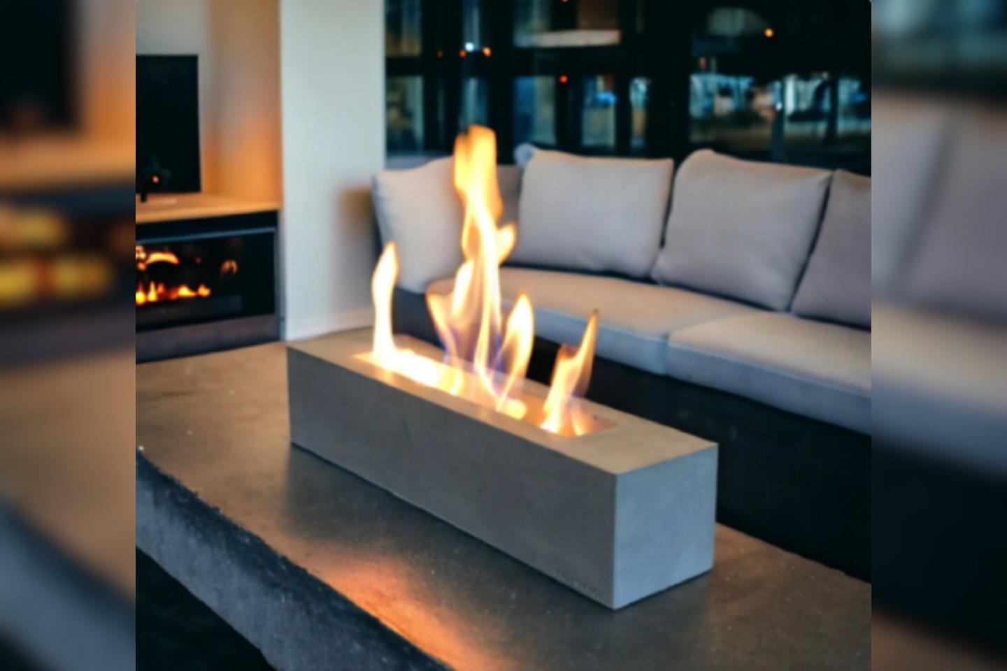 The recalled Colsen-branded Fire Pit, Rectangular model is seen on a table in front of a couch.