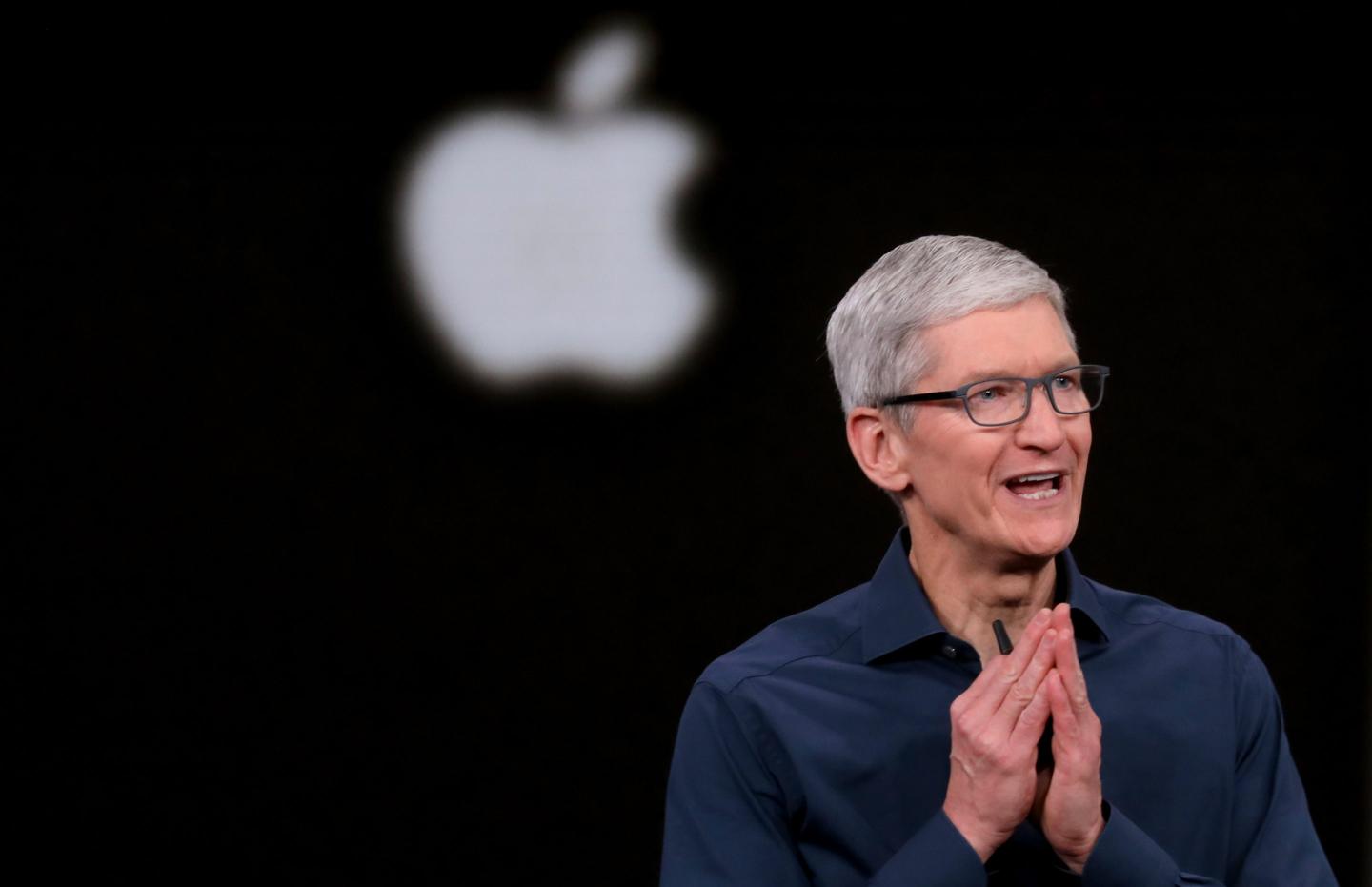 Tim Cook is seen in front of the Apple logo.