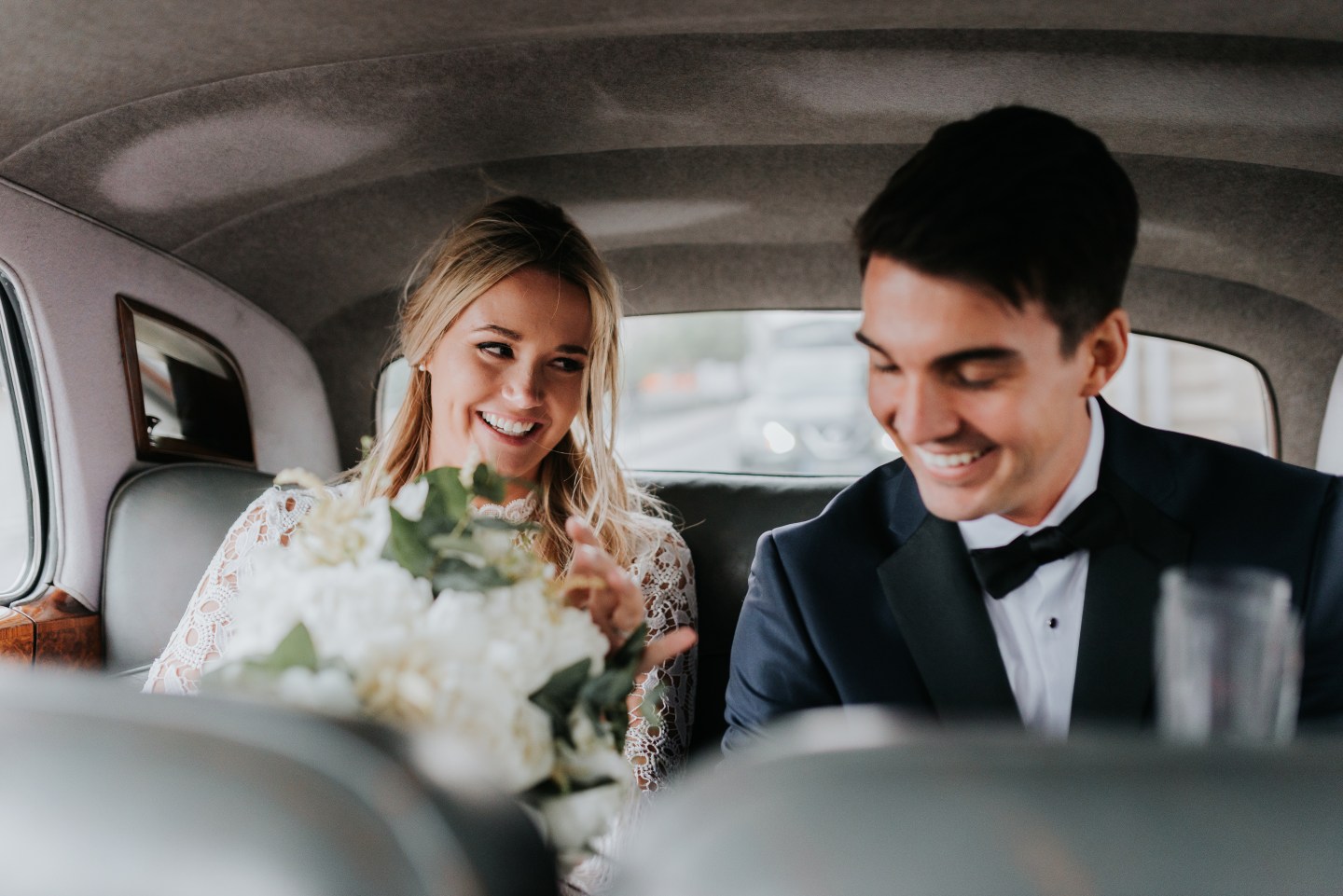 Bride and bridegroom in back seat of car