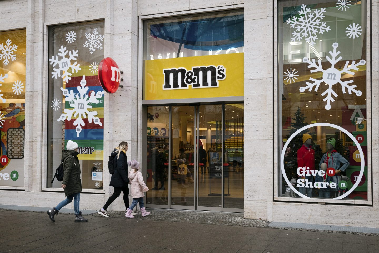 people walking past an M&M store