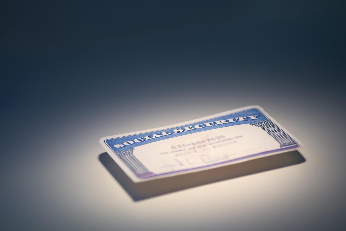 A Social Security card is illuminated on a table