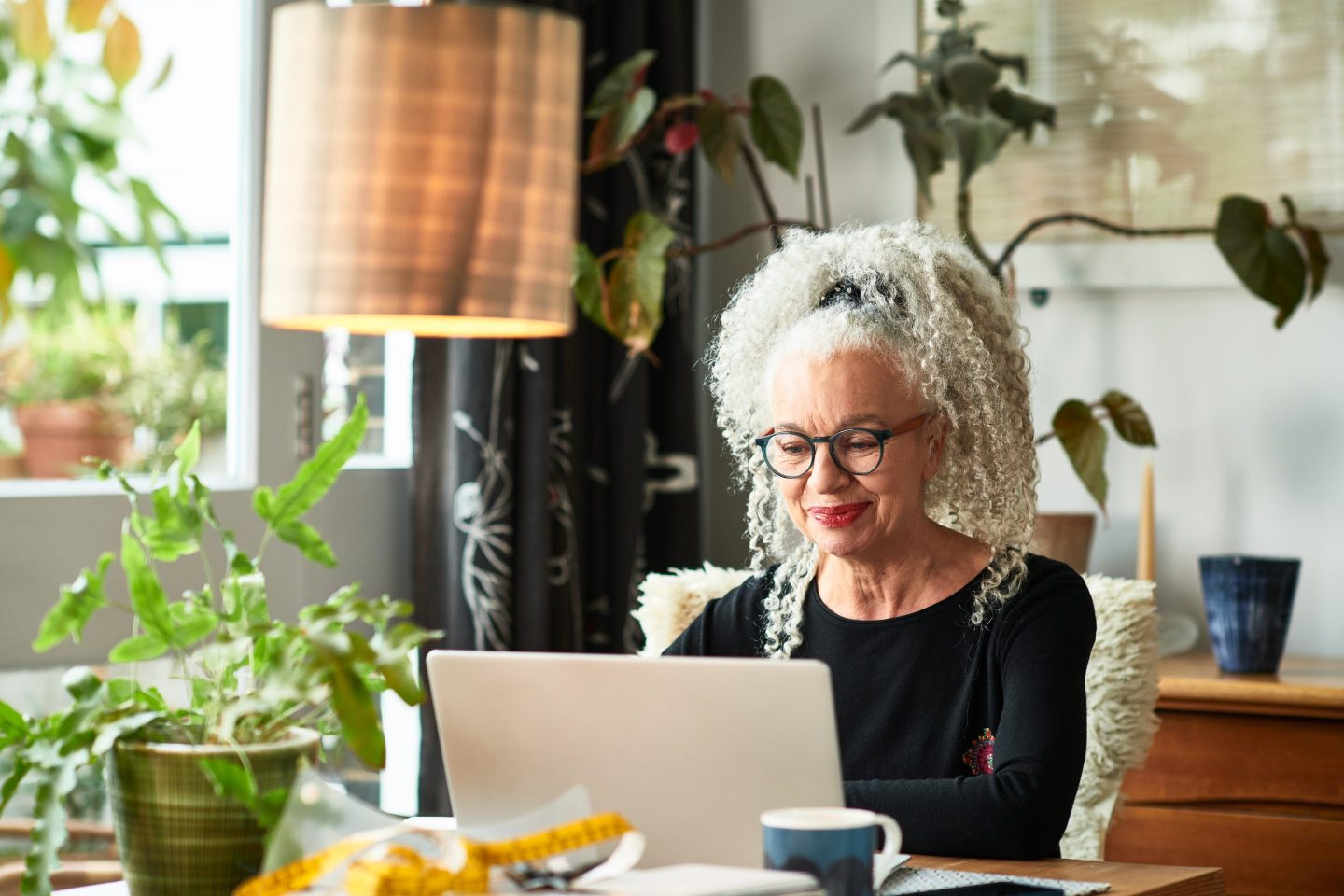 Woman with gray hair looks at her computer screen
