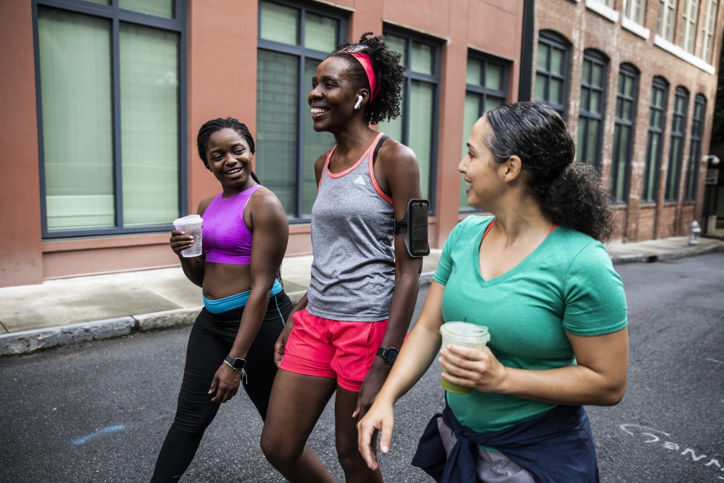 Three female runners walking after a workout