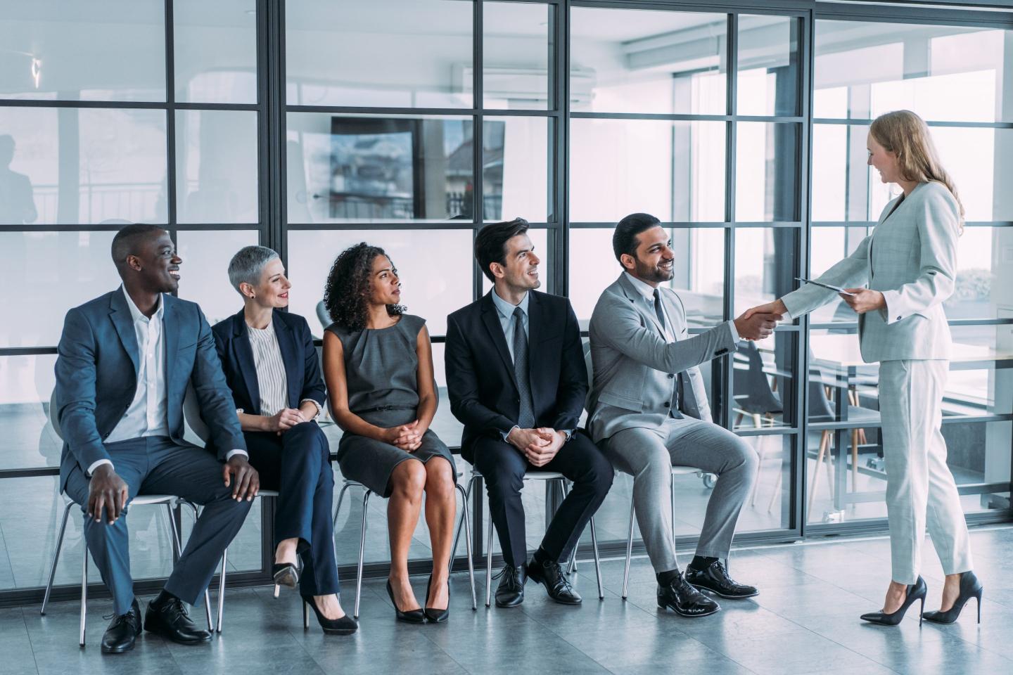 Hiring manager greets group of applicants.