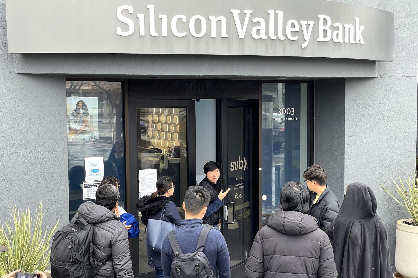 A worker tells people that the Silicon Valley Bank (SVB) headquarters is closed on March 10, 2023, in Santa Clara, Calif.
