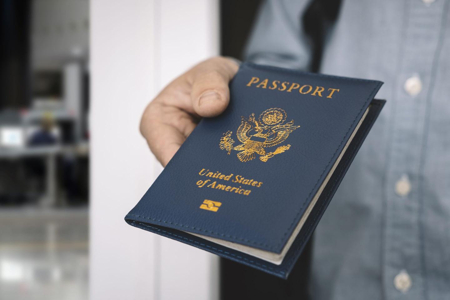 hand holding passport with bokeh background, jorney and travel concept. Passport check at the border. A man will find a passport for obtaining a visa at airport.