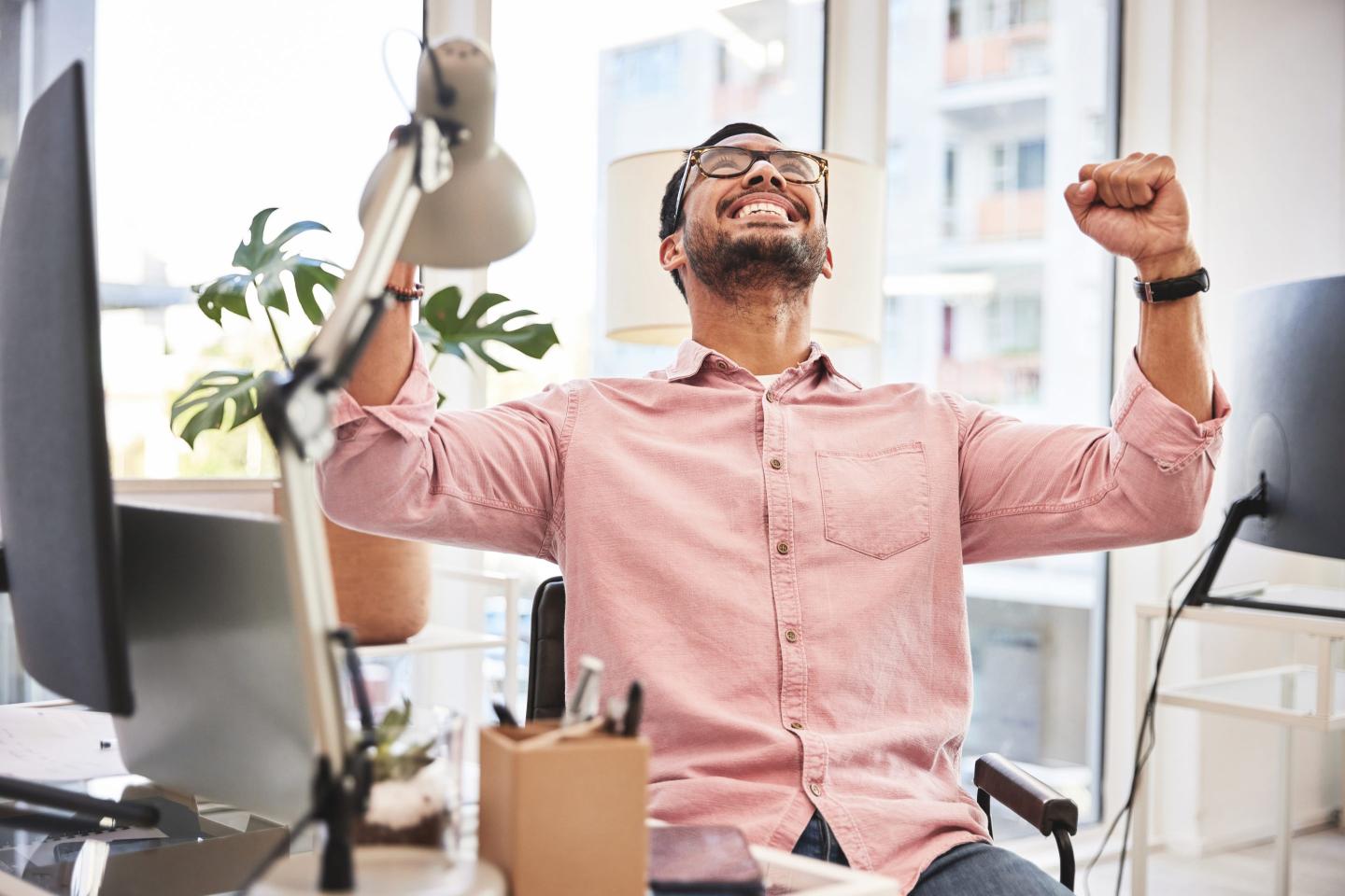 Worker cheers at desk.