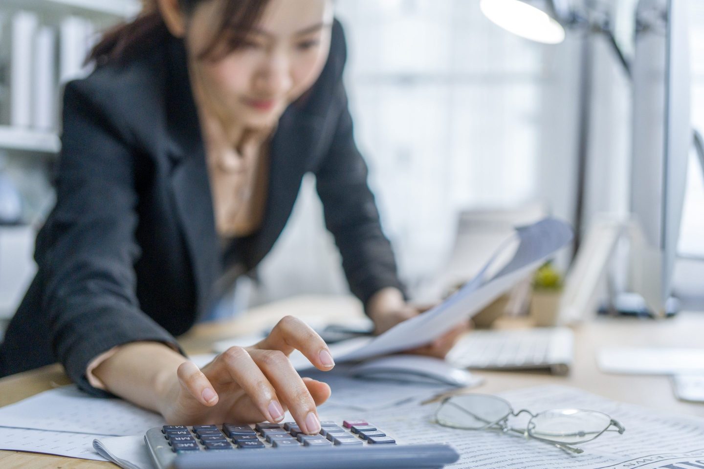 Closeup of businesswoman's hand using a calculator.