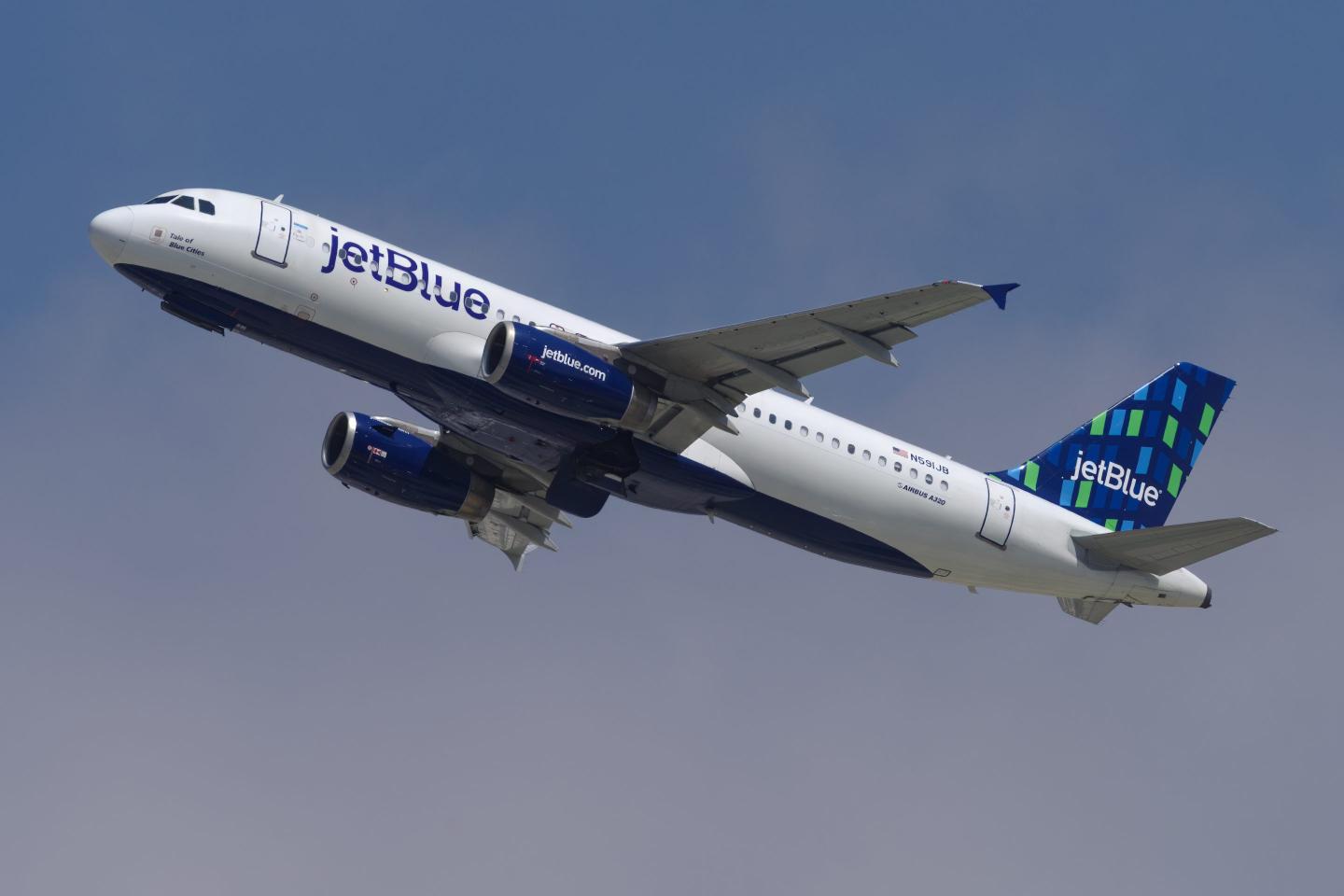 A Jet Blue plane is seen mid-takeoff.