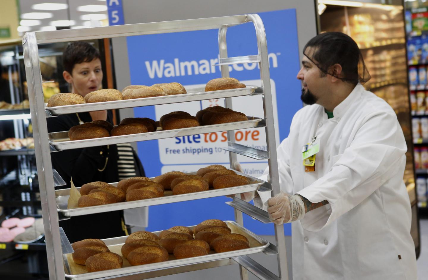 A bakery employee pushes a cart of fresh baked rolls during the grand opening of a Wal-Mart Stores Inc. location in the Chinatown neighborhood of Los Angeles