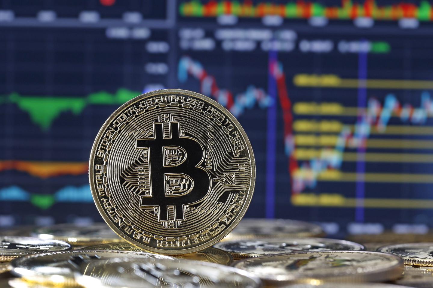 In this photo illustration, a visual representation of the digital cryptocurrency Bitcoin is displayed in front of a Bitcoin course's graph on February 13, 2024 in Paris, France.