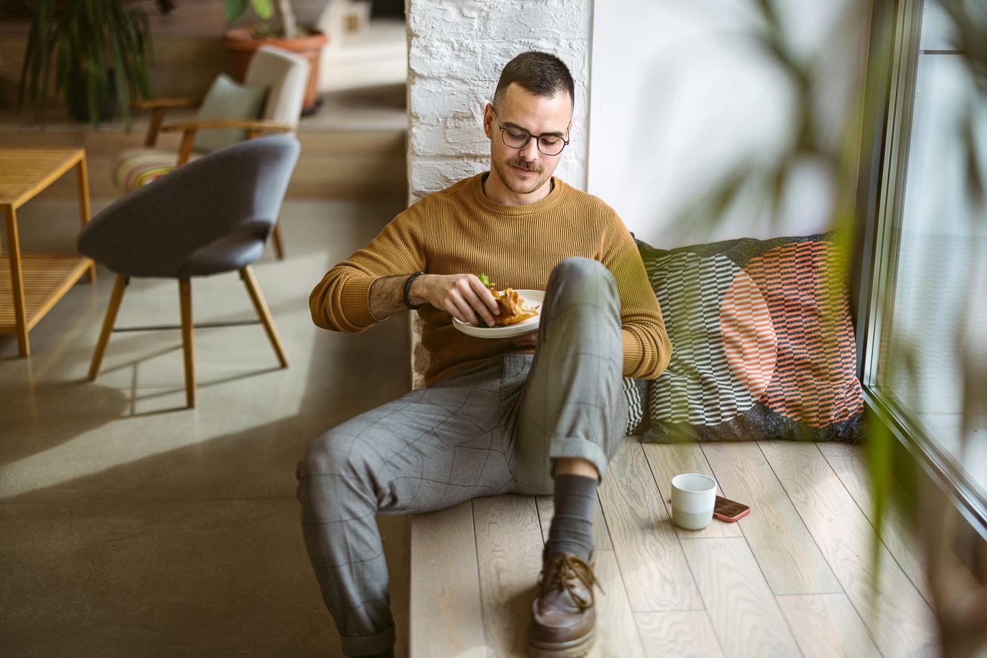 Man eats at work while sitting on the floor