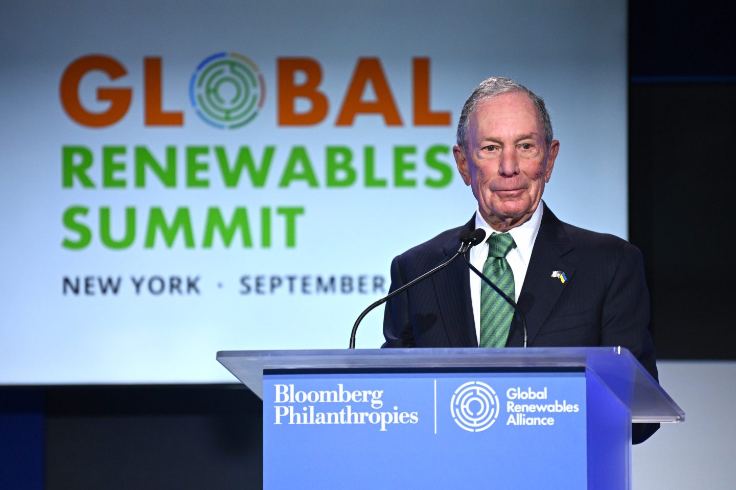 Michael Bloomberg stands at a podium for Bloomberg Philanthropies