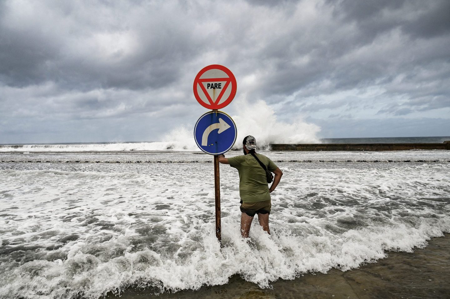 A man looks at waves crashing against the Malecon promenade in Havana due to the passage of Hurricane Milton on October 9, 2024.