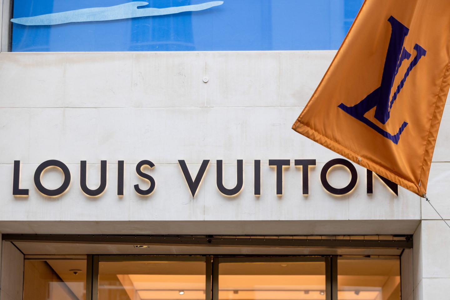 The exterior of a Louis Vuitton boutique, with the logo and a flag clearly visible.
