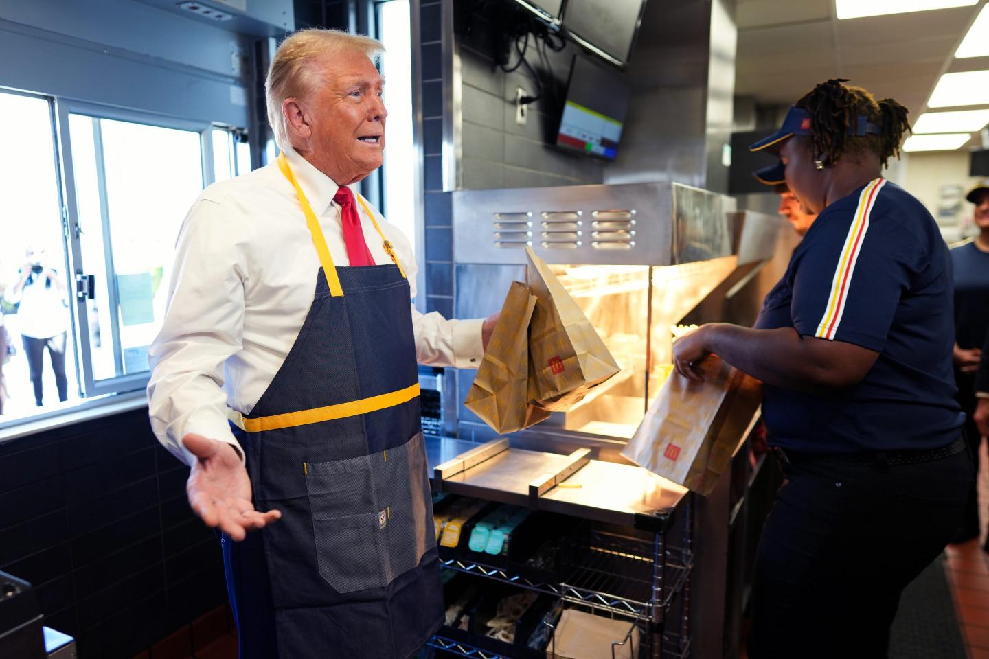 Republican presidential nominee, former U.S. President Donald Trump works behind the counter during a visit to McDonald's restaurant on October 20, 2024 in Feasterville-Trevose, Pennsylvania.