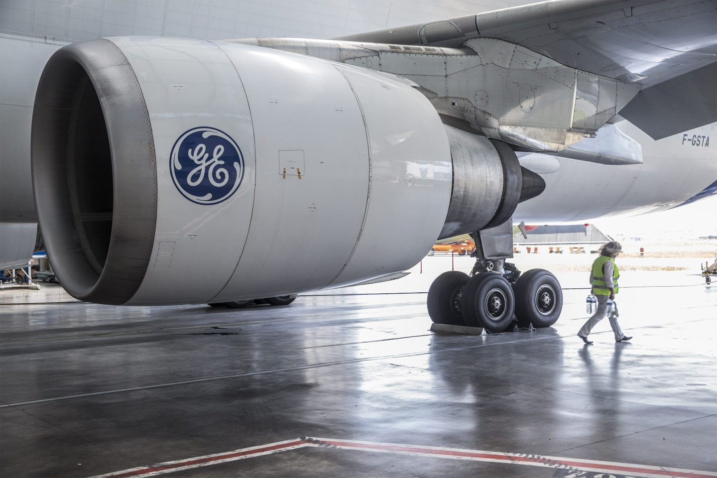 The General Electric Co. (GE) logo sits on a GE Aviation CF6-80C jet engine as it hangs from the wing of an Airbus A300-600 Beluga super transporter aircraft in the Airbus Group NV factory.