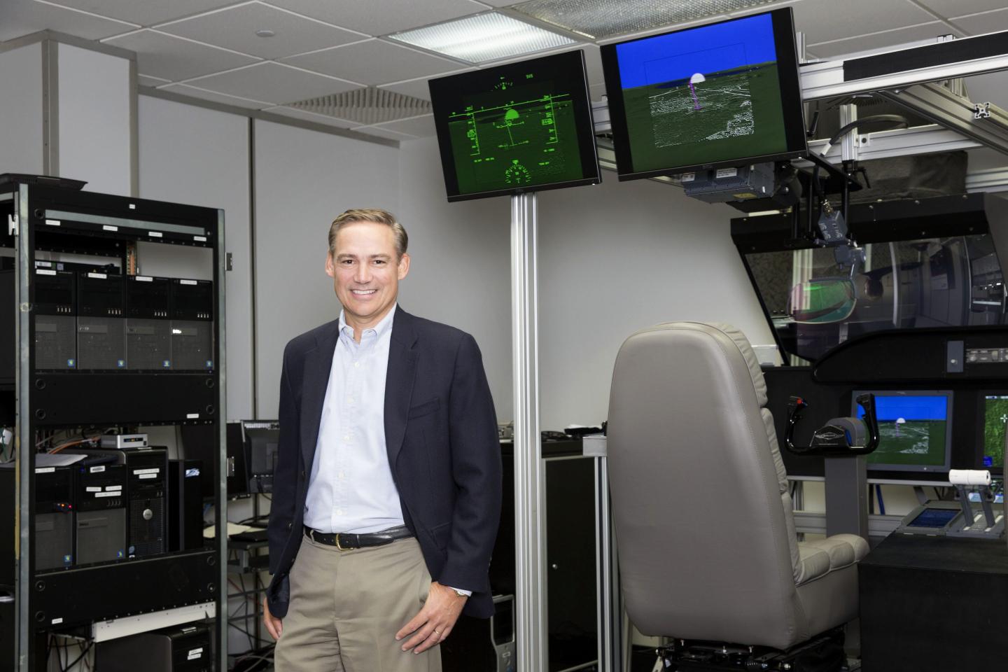 Kelly Ortberg stands near screens