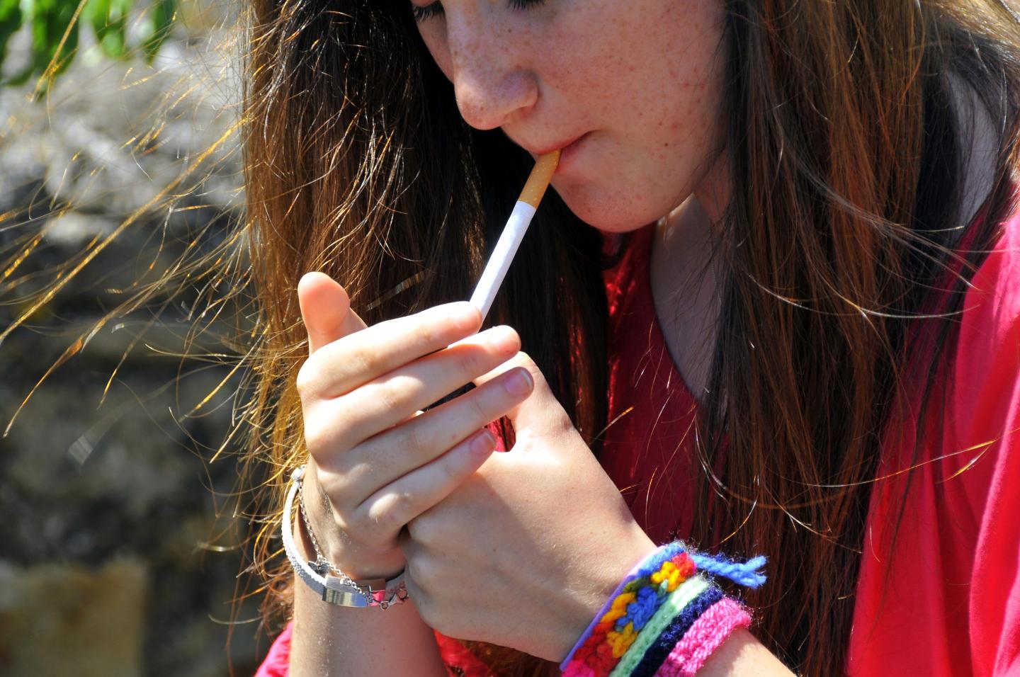 Teenager lighting up a cigarette.