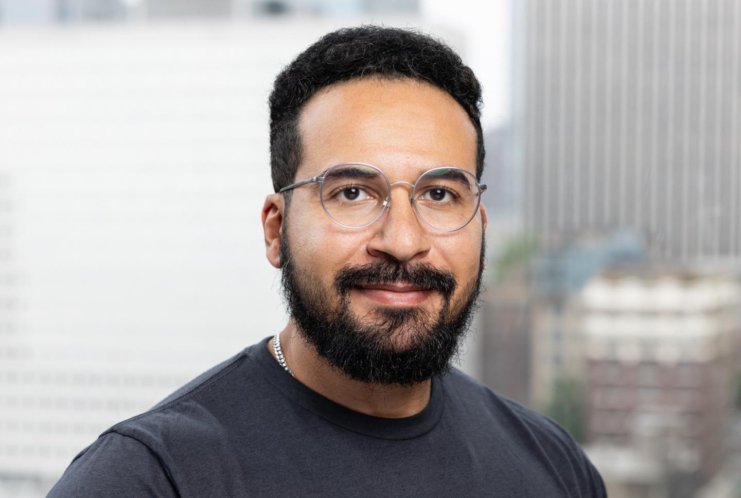 Mo Sarwat, male with dark hair and glasses poses for a photo