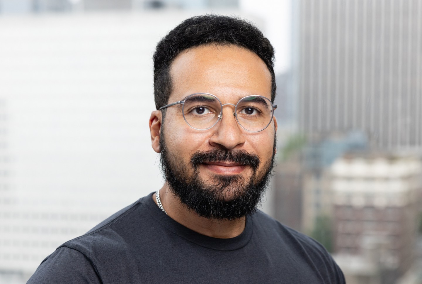 Mo Sarwat, male with dark hair and glasses poses for a photo