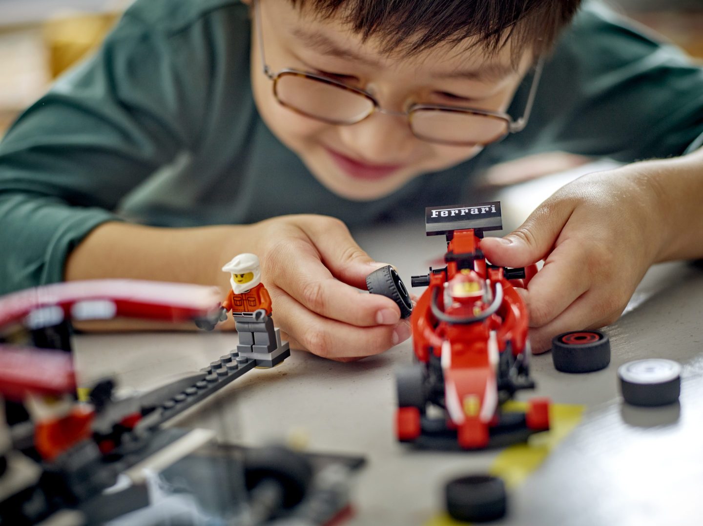 boy playing with Lego Formula 1 toy