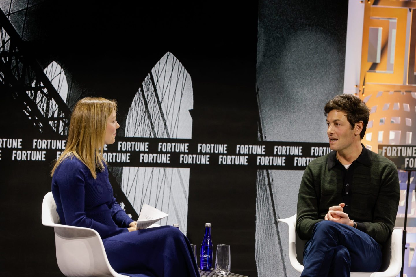 Joshua Kushner seated onstage for an interview
