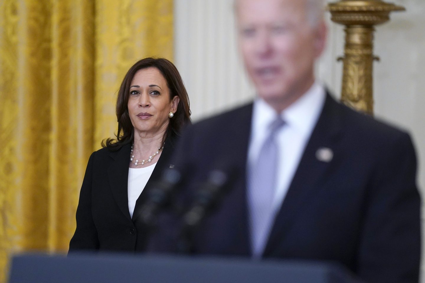 Kamala Harris stands behind Joe Biden as he speaks at the presidential podium