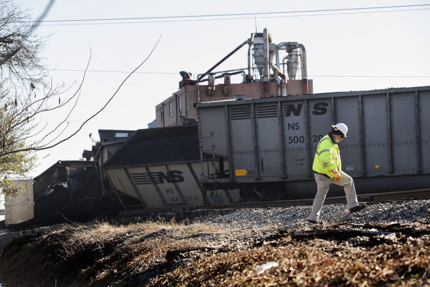 A Norfolk Southern worker walks next to the scene of a multi-car coal train derailment near Suffolk, Va., on Feb. 4, 2017.