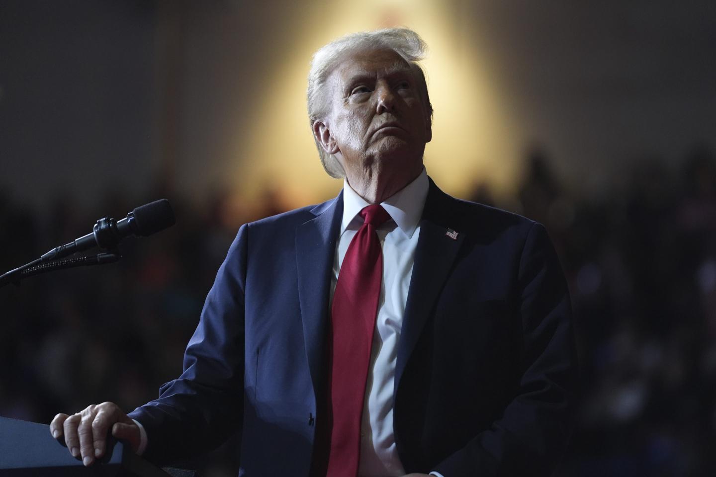 Donald Trump watching a video screen at a campaign rally.
