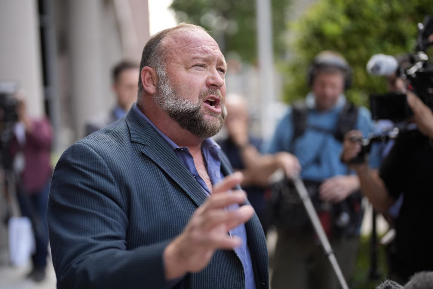 Right-wing conspiracy theorist Alex Jones speaks to the media after arriving at the federal courthouse for a hearing in front of a bankruptcy judge, Friday, June 14, 2024, in Houston.