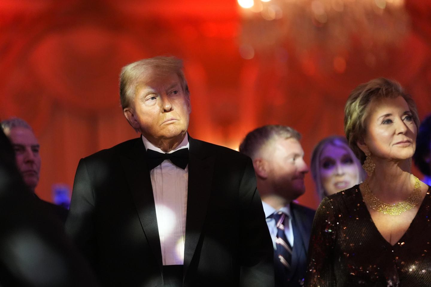 Donald Trump listens with Linda McMahon during an America First Policy Institute gala at his Mar-a-Lago estate, Thursday, Nov. 14, 2024, in Palm Beach, Fla.