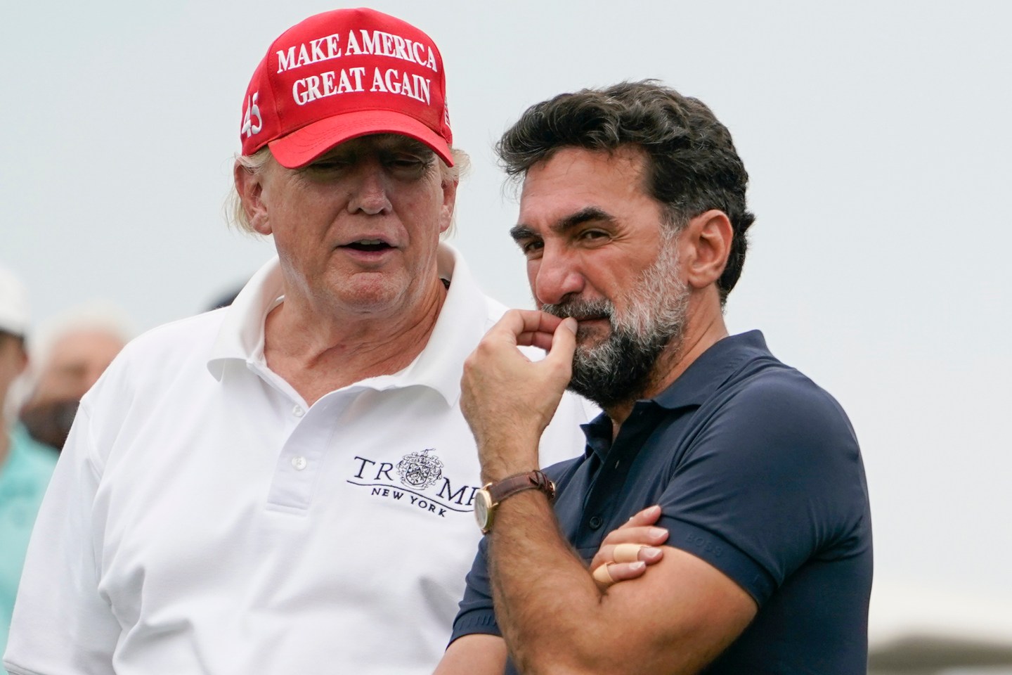 Former President Donald Trump, left, talks with Yasir Al-Rumayyan, governor of Saudi Arabia's Public Investment Fund, on the 16th hole during the first round of the Bedminster Invitational LIV Golf tournament in Bedminster, NJ., July 29, 2022. Trump joined the “Let's Go!" podcast with Jim Gray and Bill Belichick on the eve of the election and said, “it would take me the better part of 15 minutes to get that deal done.”
