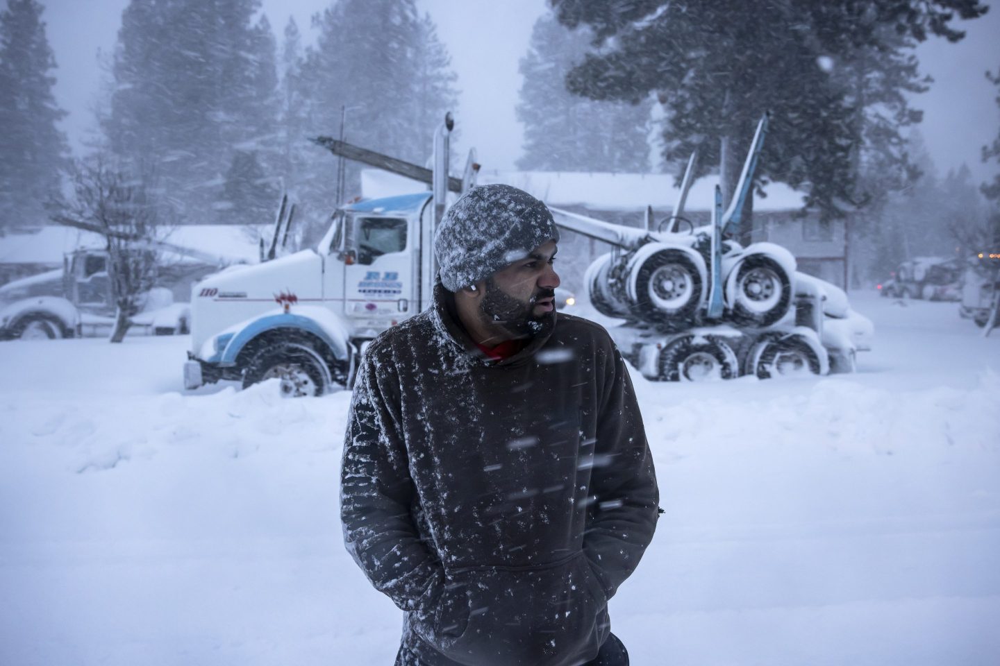 Truck driver Harry Singh of Seattle looks down Shastina Drive where several dozen big rigs were gathered after being stuck overnight in Weed, Calif., on Nov. 20, 2024.