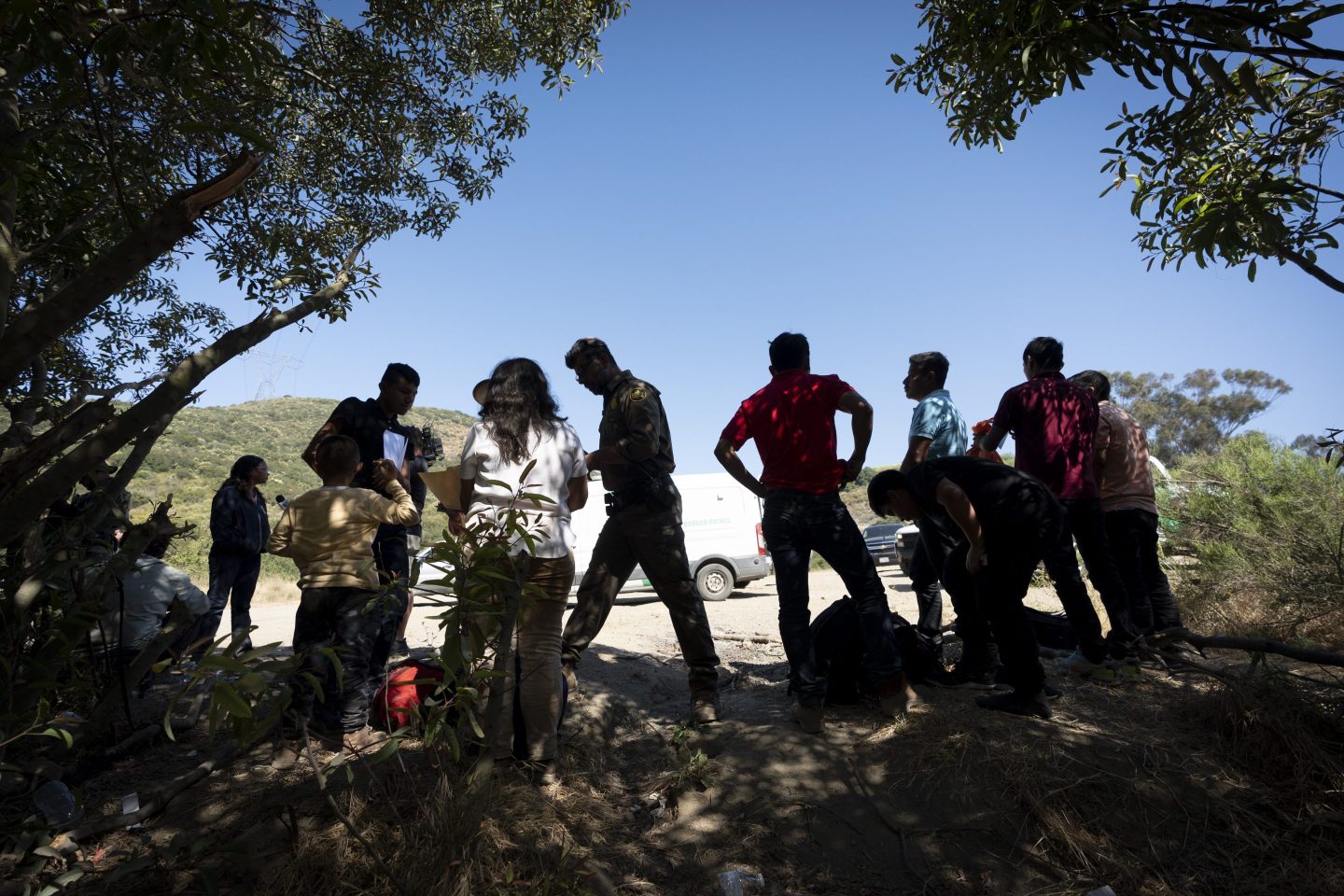 Border Patrol agents talk with migrants seeking asylum as they prepare them for transportation to be processed, June 5, 2024, near Dulzura, Calif.