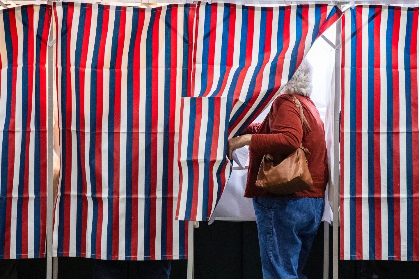 A person enters a voting booth at a polling station at Colebrook Academy and Elementary School in Colebrook, New Hampshire, on Election Day, November 5, 2024.