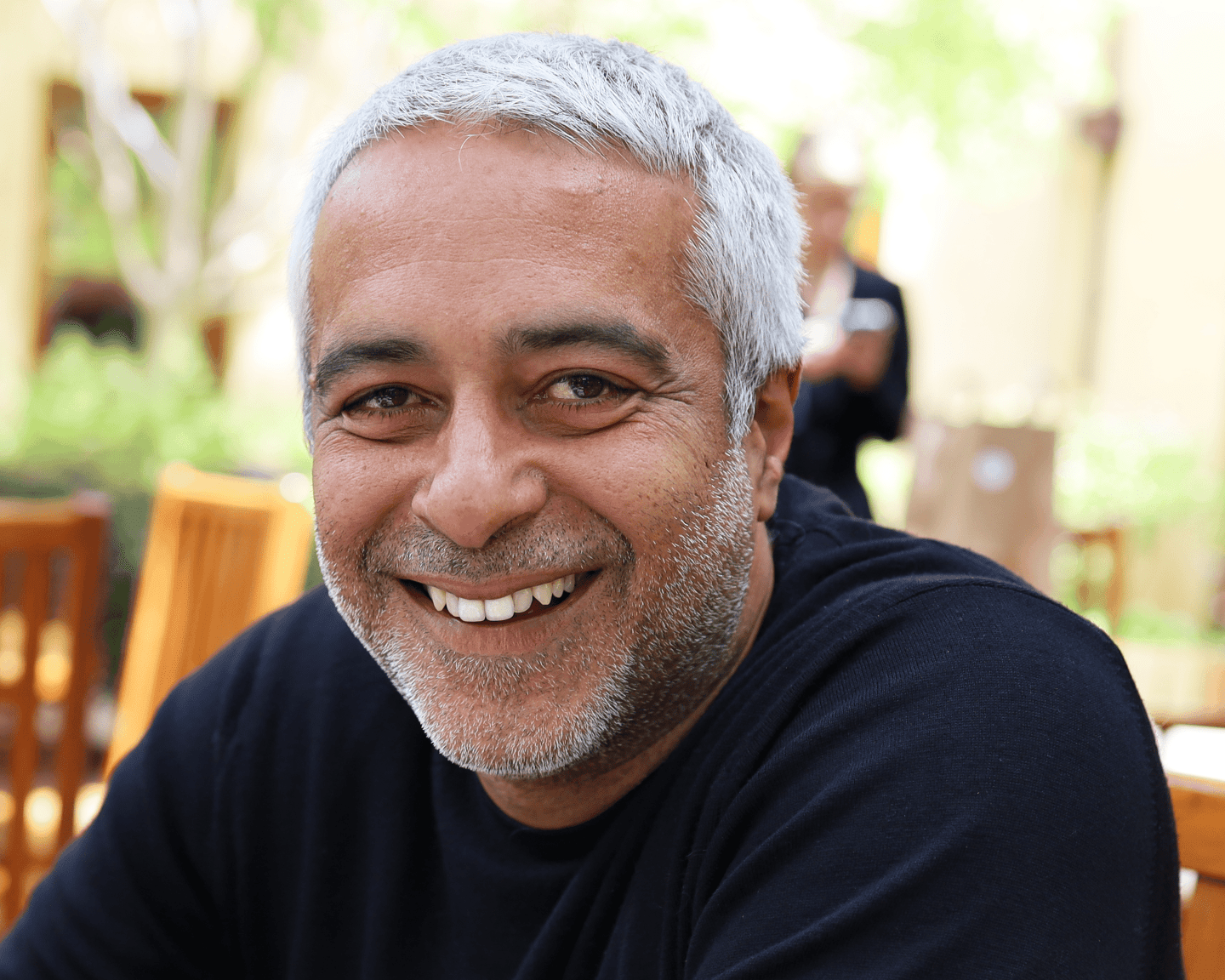 gray-haired man wearing a black shirt and smiling
