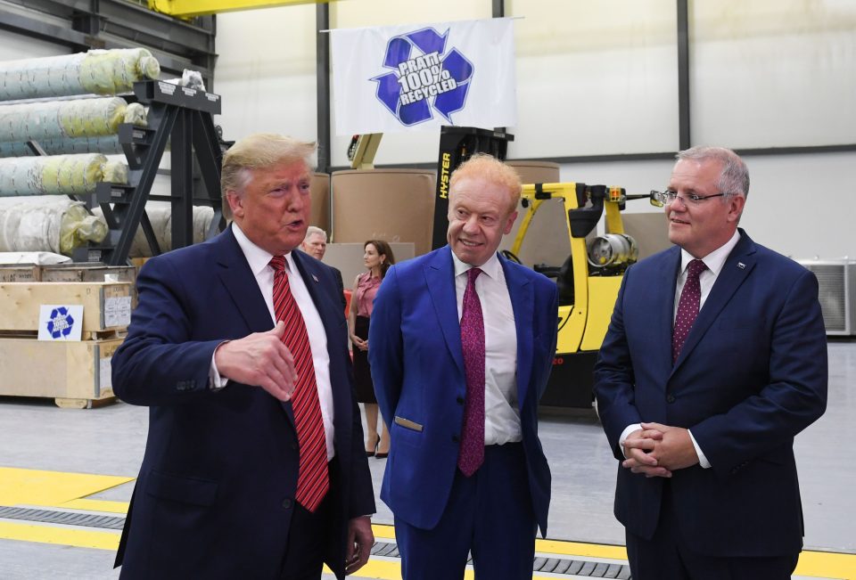 Donald Trump, Anthony Pratt, and Scott Morrison stand next to each other on the floor of a paper plant.