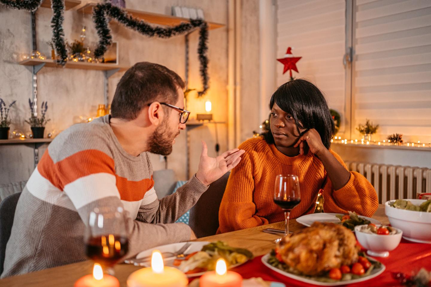 Two people have an awkward interaction over a festive meal