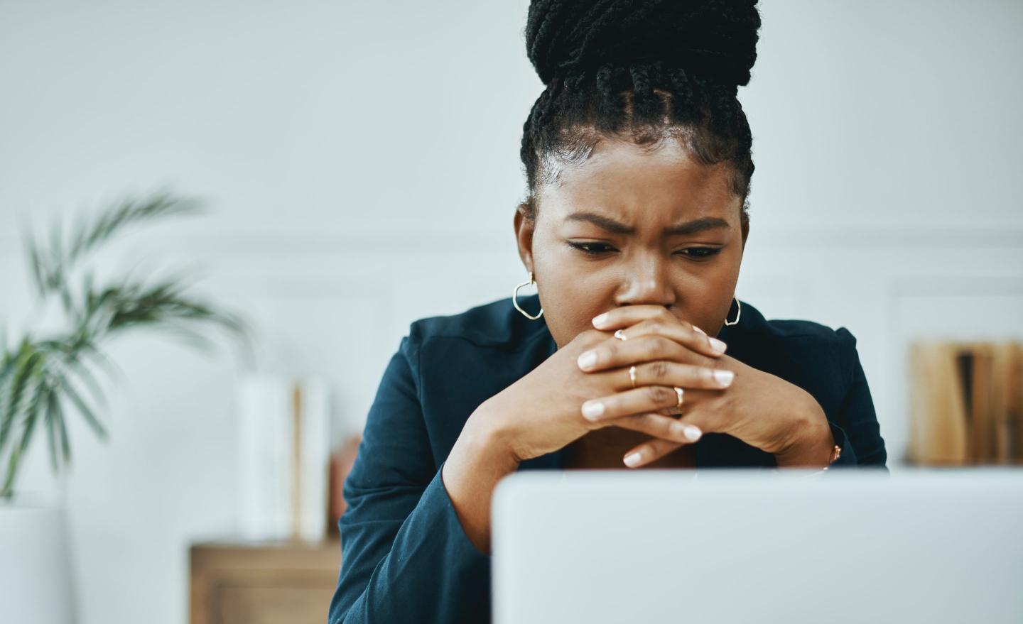 Working woman is stressed at desk.