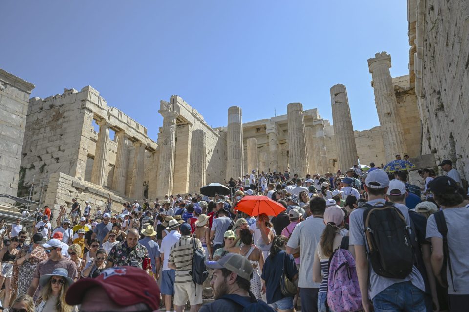 A large crowd of tourists visit the Parthenon Temple