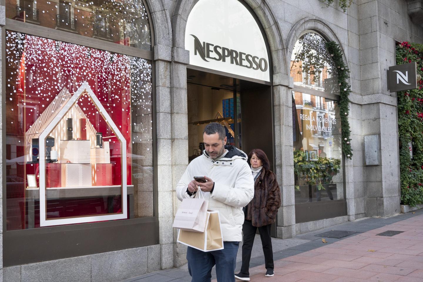 people walking past a nespresso store