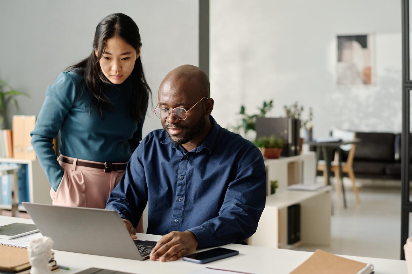 Female and male coworkers in conversation at the office.