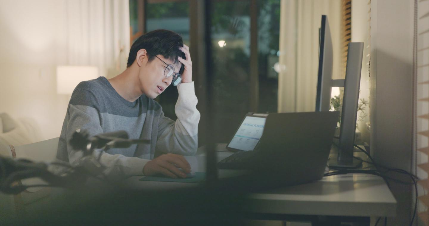 An overworked businessman experiences stress and frustration while working late at home.